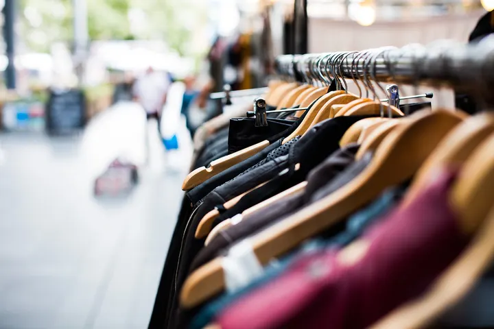 Percheros con ropa colgada en el salón de ventas